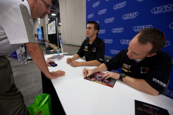 Professional racecar drivers Billy Johnson and Jack Roush Jr. sign autographs at the 2011 USANA International Convention.