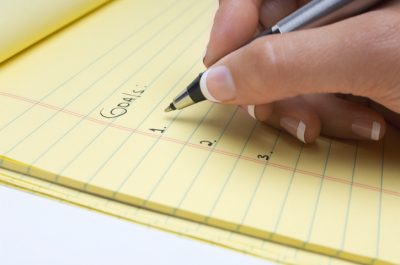 Woman writing list of goals,  close-up of hand