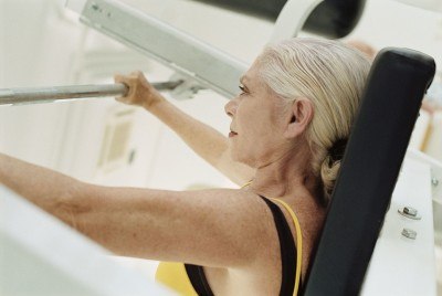 Senior woman weight training in a gym