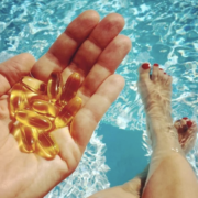 Hand Holding Fish Oil Supplements in Pool