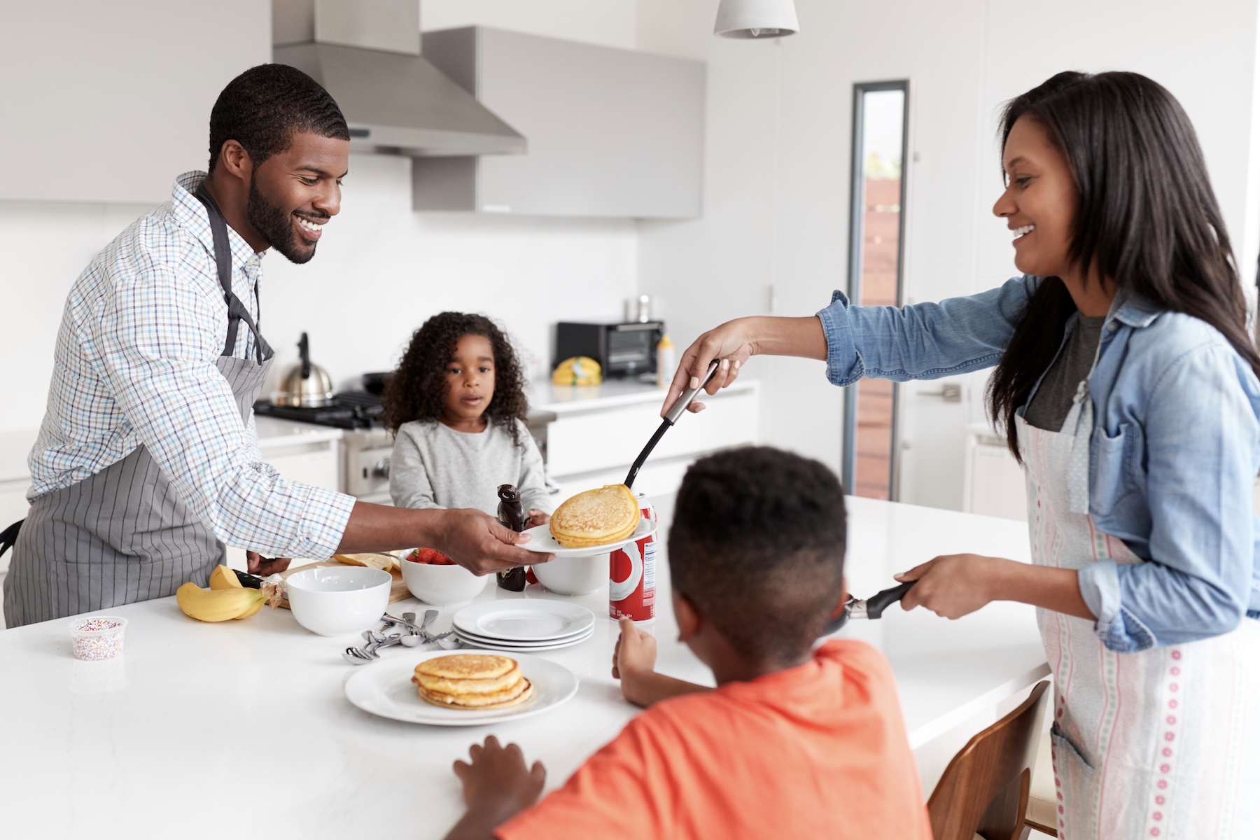 smiling family sharing a brunch of pancakes