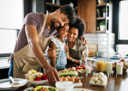 Happy african american family preparing healthy food in kitchen together