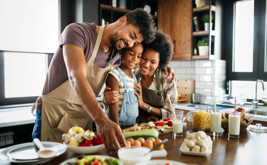 Happy african american family preparing healthy food in kitchen together